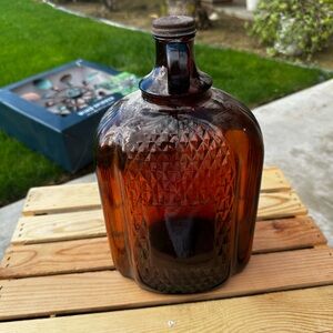 This is a one-gallon amber glass jug, likely a vintage or collectible item